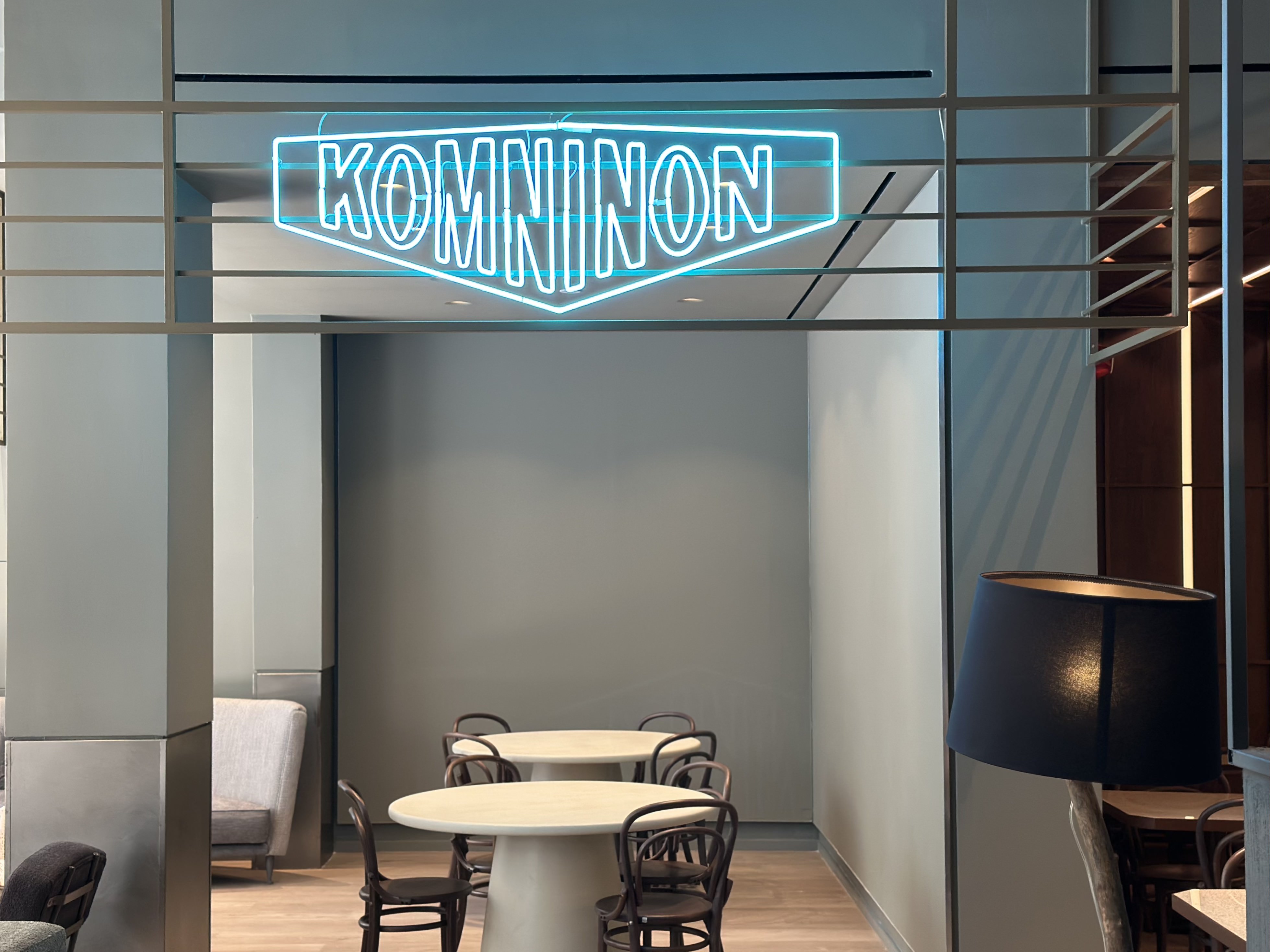 
Komninon bar at City Hotel, featuring modern minimalist seating and a striking neon sign